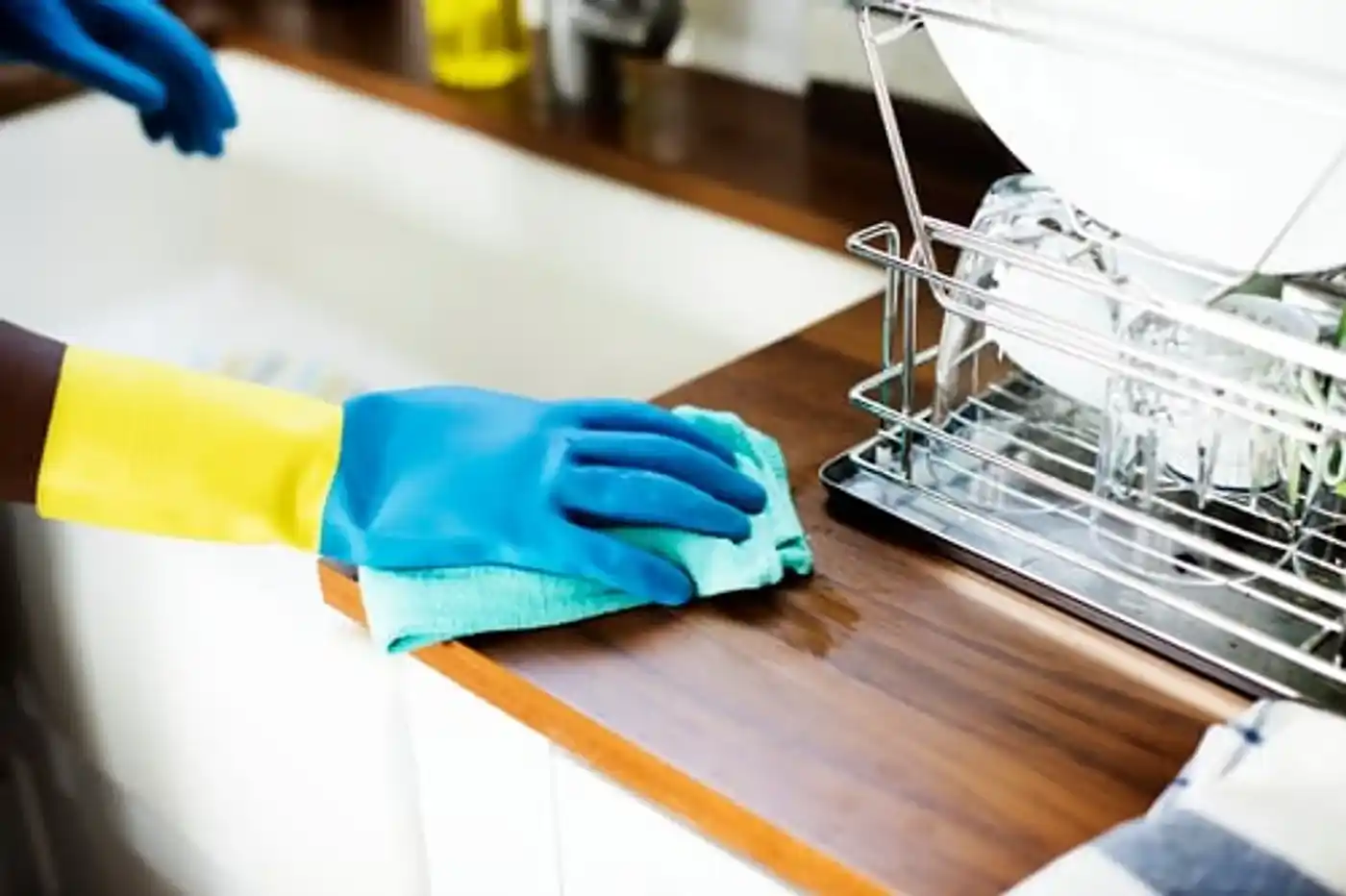 Wiping down a wooden kitchen counter during a one-time house cleaning